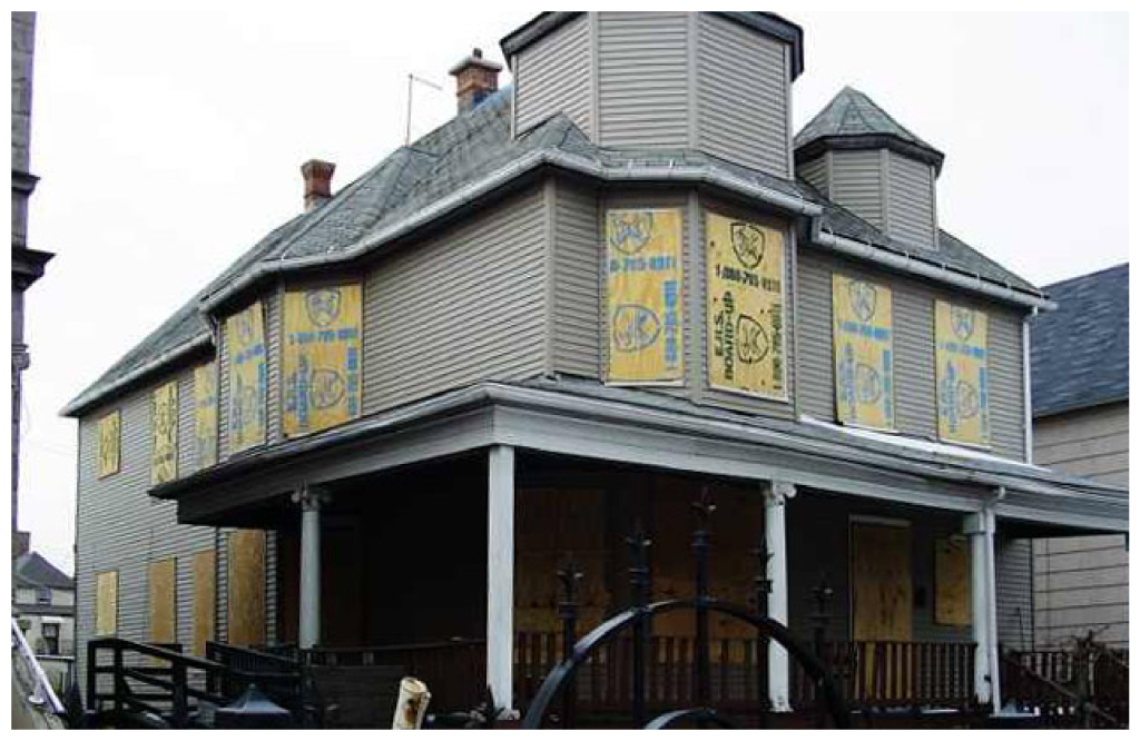 The mansion facade during an earlier era, its boarded windows covered with painted African and Egyptian art panels.